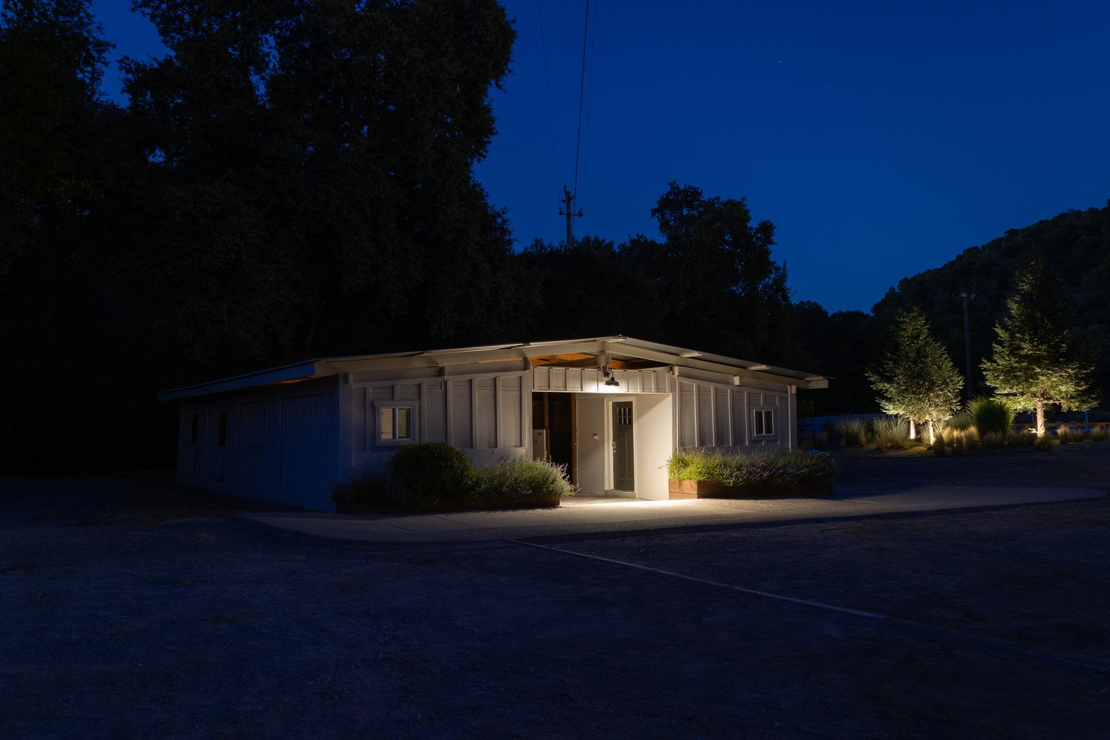 A white farm building illuminated at dusk at Hindsight Farms.
