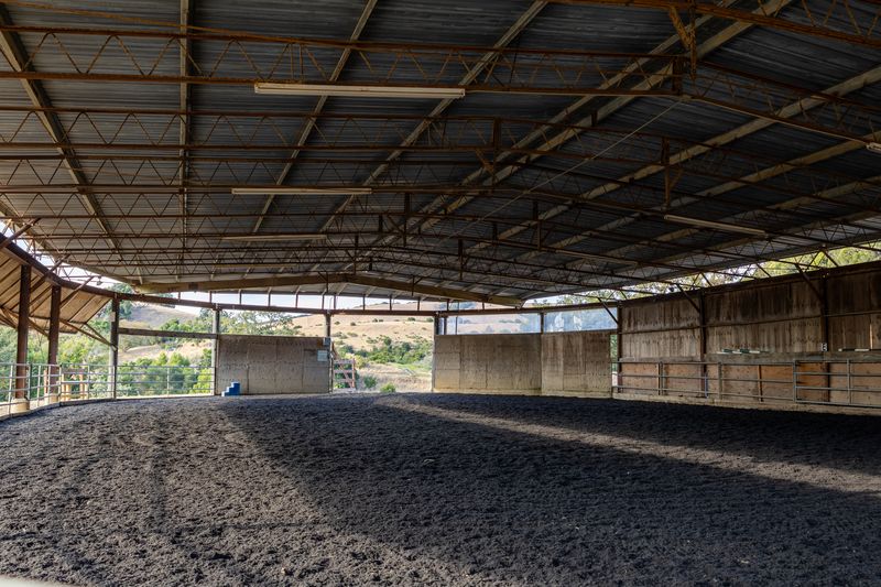 Covered arena looking toward the open end and the dry hillside beyond