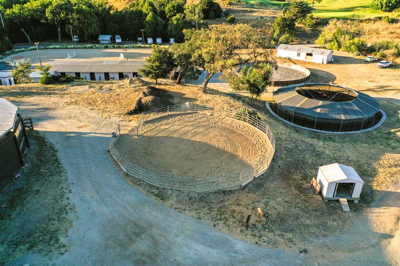 Aerial view of the round pen and roofed Eurociser with deer on the hillside